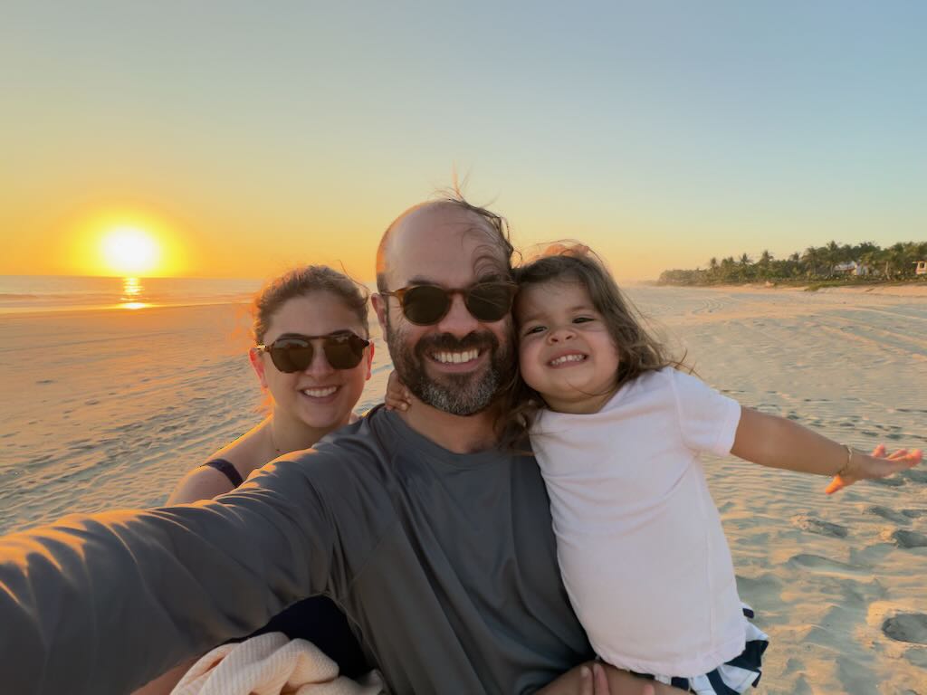 Family selfie on the beach at sunset